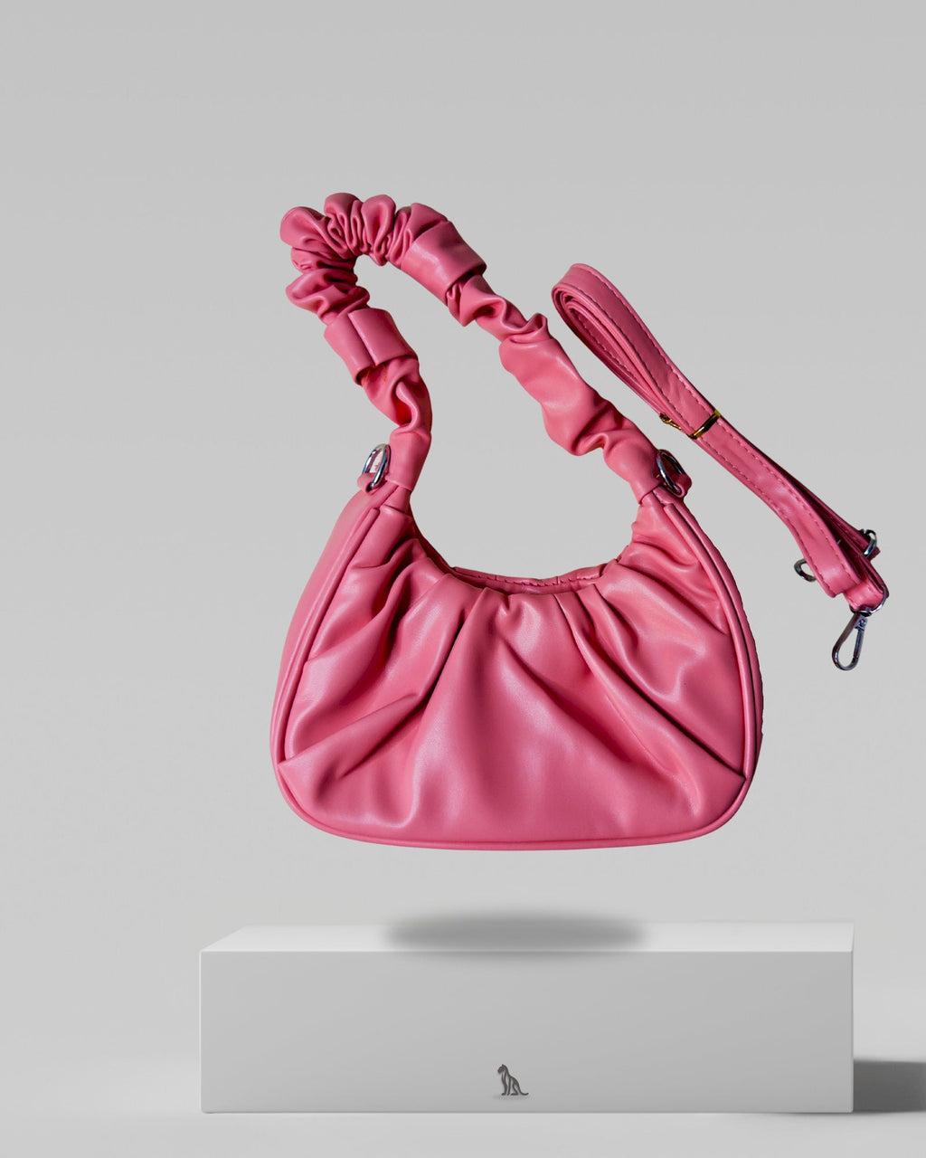Pink handbag with a strap on a light gray background