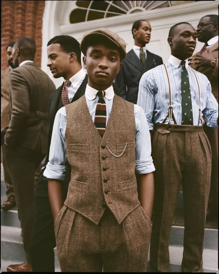 Group of young men in formal attire standing on steps in front of a building.